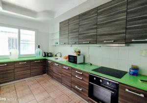 a kitchen with wooden cabinets and green counter tops at Villa Olympus Sea View Private Pool 4BR Near Kata Beach in Kata Beach
