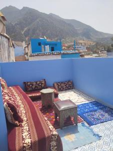 a blue room with a couch and a table at FATI GUEST HOUSe in Chefchaouen