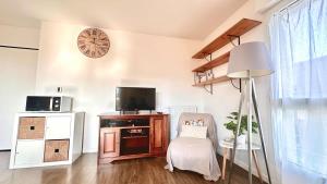 a living room with a chair and a clock on the wall at Rotamagus Officiel in Rouen
