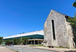 an old stone building with a large building at Rotamagus Officiel in Rouen