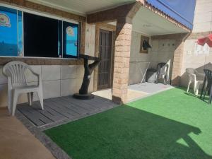 a house with a green lawn on the front porch at Recanto dos Loureiros in Saquarema