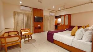 a hotel room with a bed and a tv at Bliss Giriya By Bergamont in Tiruvannāmalai