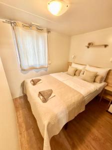 a bedroom with a large bed with two pillows on it at Mobile Home David-Camp Soline in Biograd na Moru