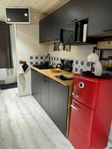 a kitchen with a red refrigerator and a counter at Le Refuge in Margencel