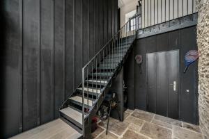 a metal staircase in a gym with black walls at The Hayloft in Strabane