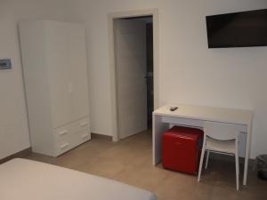 a room with a desk with a chair and a red suitcase at Esmeralda B&B in Casa San Biagio