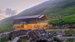 a house on top of a hill with a bridge at Sarag in Ushguli