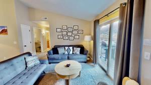 a living room with a blue couch and a table at Red Cliff Condos #3i in Moab