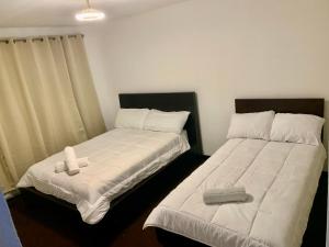 two beds sitting next to each other in a room at Zenora Suites in San José