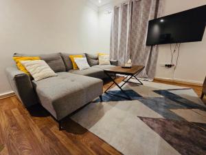 a living room with a couch and a flat screen tv at Lovely Studio apartment in Jeddah