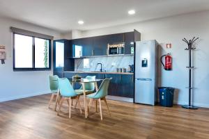 a kitchen with a table and chairs and a refrigerator at Modern Sea View Studio with Private Parking in Gaula