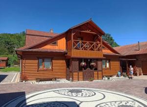 a log cabin with a courtyard in front of it at Hammam Spa Villa DAROSO in Kosiv