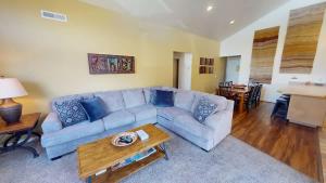 a living room with a blue couch and a table at Desert Hideaway #C2 in Moab