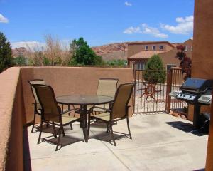 a patio with a table and chairs and a grill at Desert Hideaway #C2 in Moab