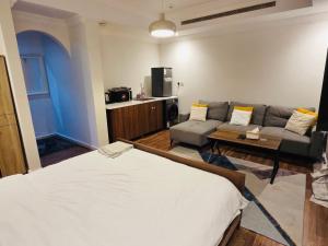 a living room with a bed and a couch at Lovely Studio apartment in Jeddah