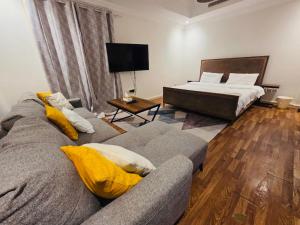 a living room with a couch and a bed at Lovely Studio apartment in Jeddah