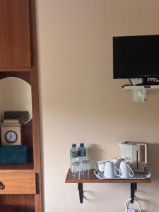a shelf with glasses and a tv on a wall at Corrib View Villa - Guest Accomodation in Cong