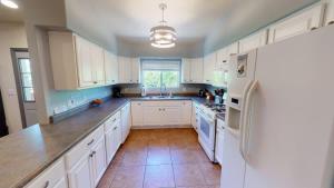 a kitchen with white cabinets and a white refrigerator at Adventure Base Camp #381 in Moab