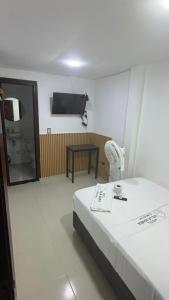 a hotel room with a bed and a television at Hotel Villa María Coworking in Villavicencio