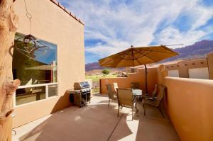 a patio with an umbrella and a table and chairs at Grey Pearl #Q3 in Moab