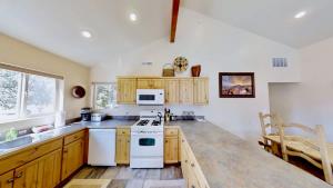 a kitchen with wooden cabinets and a white stove top oven at Grey Pearl #Q3 in Moab +26 photos