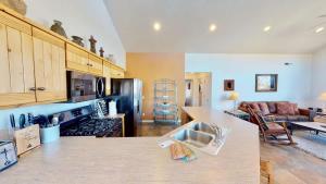 a kitchen with a counter top and a living room at Arches Abode #A3 in Moab +28 photos