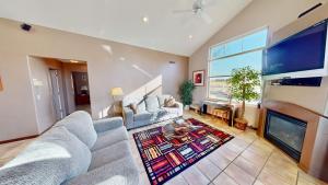a living room with a couch and a tv at Mountain Paradise #G3 in Moab