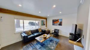 a living room with a black leather couch and a television at Moab Flats #3 in Moab