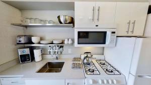 a white kitchen with a stove and a microwave at Moab Flats #3 in Moab