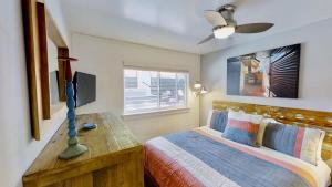 a bedroom with a bed with a desk and a television at Moab Flats #3 in Moab +25 photos
