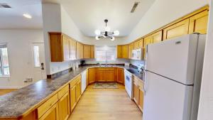 a kitchen with wooden cabinets and a white refrigerator at Portal Vista #443 in Moab