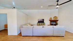 a white living room with a white couch and a tv at Portal Vista #443 in Moab