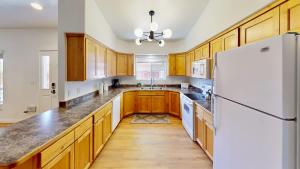 a kitchen with wooden cabinets and a white refrigerator at Portal Vista #443 in Moab