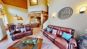 a living room with leather couches and a table at Coyote Run #4 in Moab