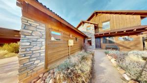 a house with a stone wall and a building at Coyote Run #4 in Moab +44 photos