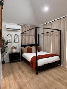 a bedroom with a black canopy bed in a room at Pearls and Palms Inn in Negril
