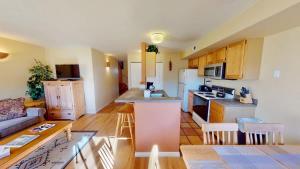 a kitchen and living room with a couch and a table at Kokopelli's Kiva #3230 in Moab