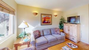 a living room with a couch and a flat screen tv at Kokopelli's Kiva #3230 in Moab