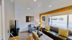 ein Wohnzimmer mit Ledersofa und Fernseher in der Unterkunft Moab Flats #2 in Moab