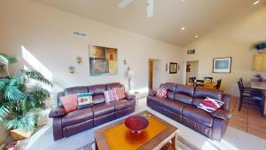 a living room with two leather couches and a table at Jan's Joy #N3 in Moab