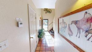 a hallway with paintings of horses on the walls at Kokopelli Dream #3251 in Moab