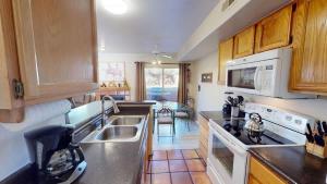 a kitchen with white appliances and wooden cabinets at Kokopelli Dream #3251 in Moab +22 photos