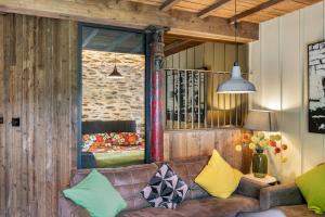 a living room with a brown couch with colorful pillows at The Stables in Bearney
