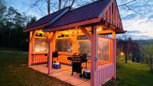 a small house with a grill in the yard at Skyline Cabins in Ingonish