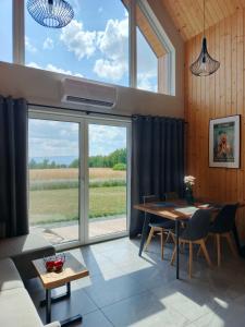 a dining room with a table and a large window at Zielone Wzgórze komfortowy klimatyzowany domek z balią z aeromasażem in Kłodzko