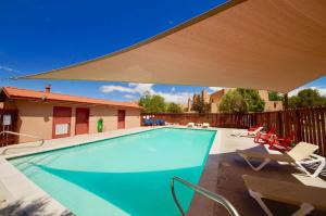 a swimming pool with chairs and a large umbrella at River Days #3326 in Moab