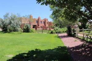 a green yard with a fence and a house at River Days #3326 in Moab +37 photos