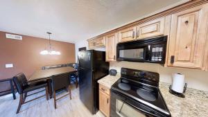 a kitchen with a black refrigerator and a table at Red Cliff Condos #1B in Moab