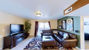 a living room with a couch and a flat screen tv at Red Cliff Condos #1B in Moab