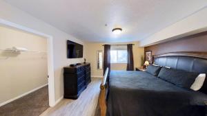 a bedroom with a bed and a dresser and a television at Red Cliff Condos #1B in Moab +12 photos